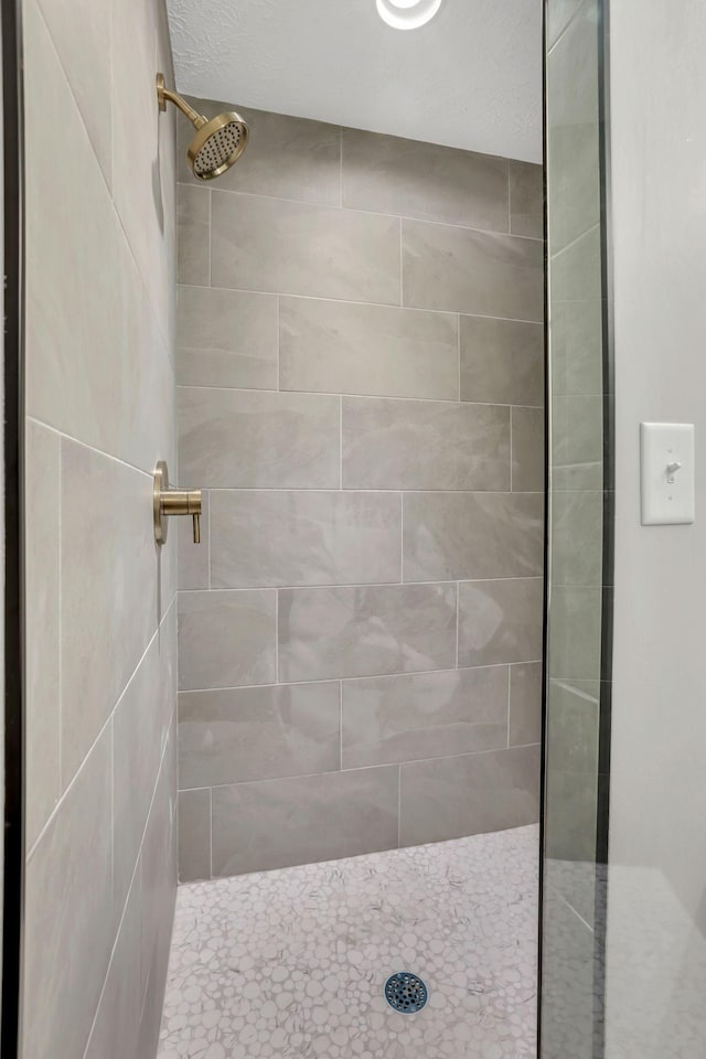 full bath featuring tiled shower