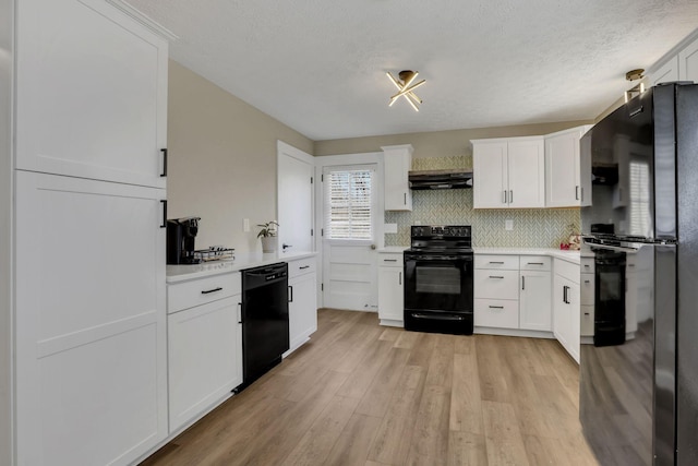 kitchen featuring light wood-style flooring, under cabinet range hood, light countertops, backsplash, and black appliances