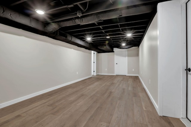 finished basement featuring wood finished floors and baseboards