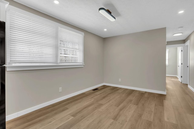 unfurnished room with recessed lighting, visible vents, baseboards, and wood finished floors