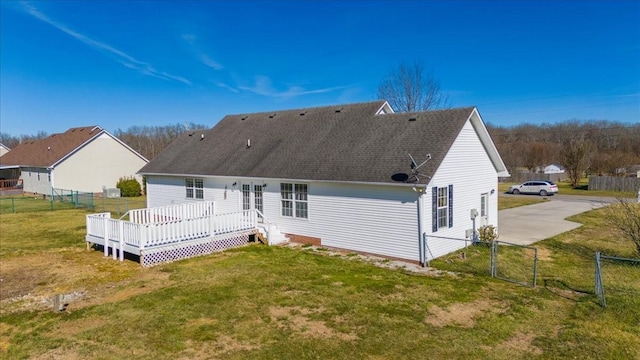 back of property with a wooden deck, a gate, fence, and a yard