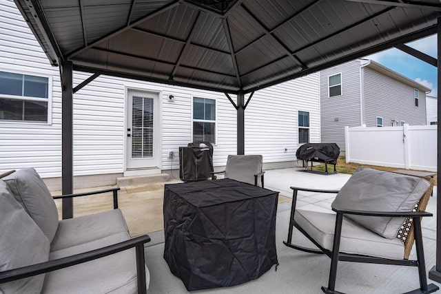 view of patio with area for grilling, fence, a gazebo, and an outdoor hangout area