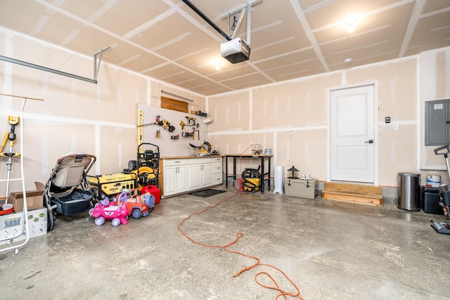 garage with a garage door opener, electric panel, and a workshop area