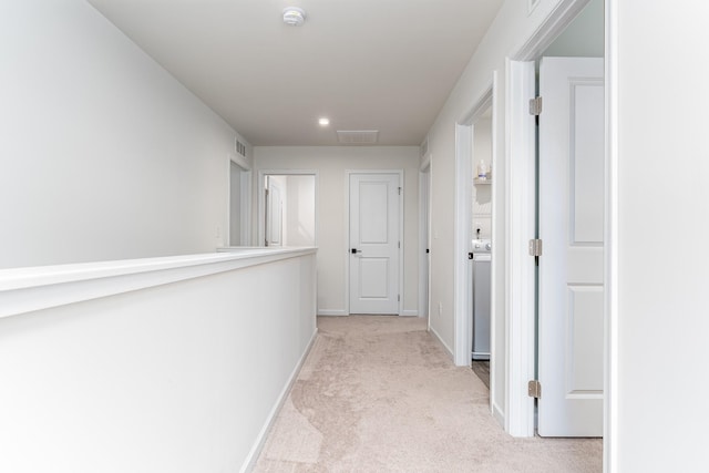 corridor with light carpet and baseboards