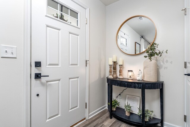 entryway featuring visible vents, baseboards, and wood finished floors