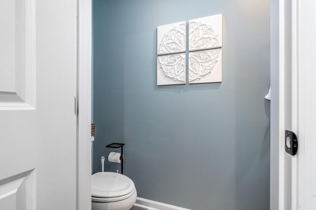 bathroom with toilet and baseboards