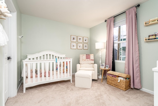 bedroom with a crib, carpet, and baseboards