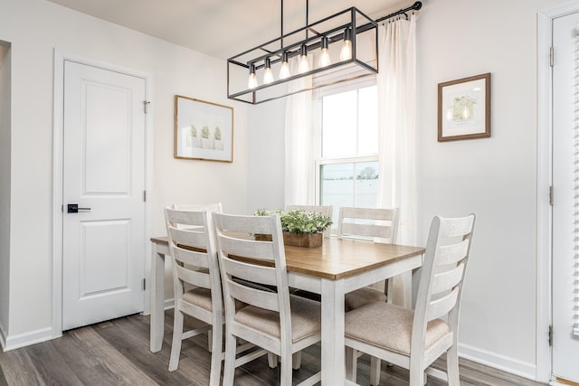 dining space featuring dark wood-style floors and baseboards