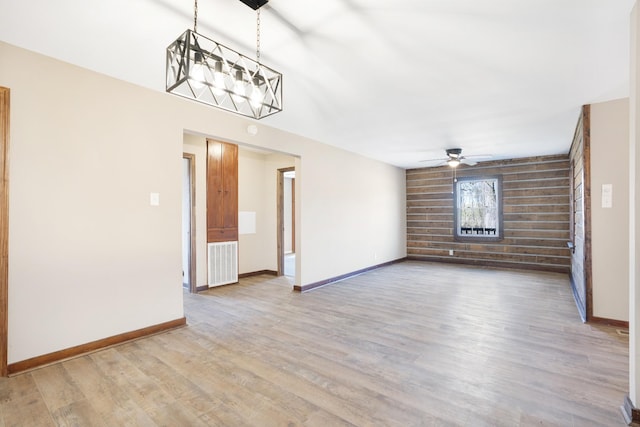 unfurnished living room featuring baseboards, visible vents, wood finished floors, and ceiling fan