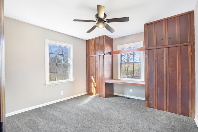 unfurnished bedroom featuring built in desk, carpet, baseboards, and visible vents