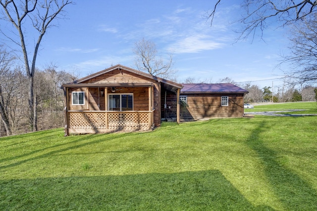 back of house featuring covered porch and a lawn