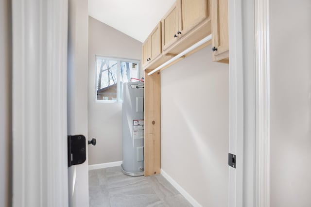 hall with water heater, baseboards, and lofted ceiling