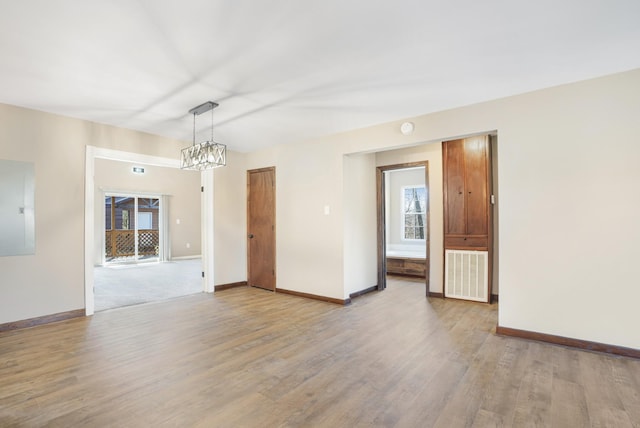 spare room featuring light wood-style floors, baseboards, and visible vents
