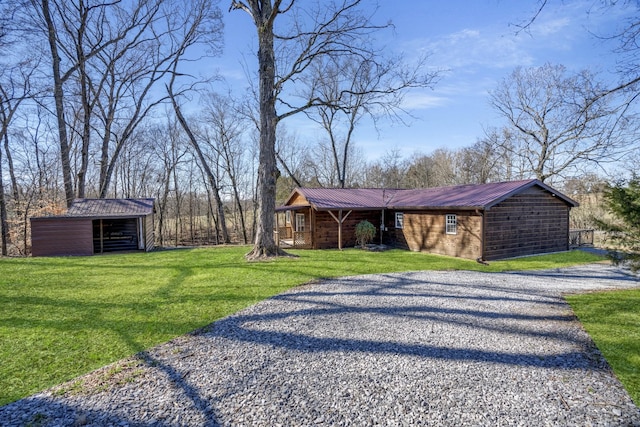 view of side of home featuring a pole building, an outdoor structure, metal roof, gravel driveway, and a yard