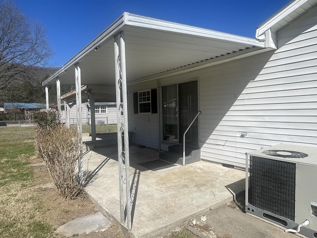 property entrance with a patio area, central AC, and fence