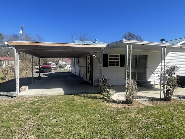 exterior space featuring entry steps, metal roof, a front lawn, and a carport