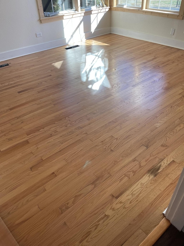 room details featuring baseboards, visible vents, and wood finished floors