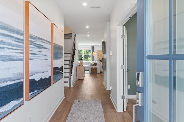 hall with recessed lighting, visible vents, baseboards, and wood finished floors