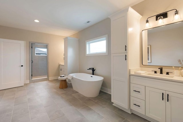 full bath with a soaking tub, a shower stall, baseboards, and vanity