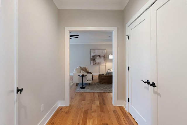 hallway with light wood-type flooring and baseboards