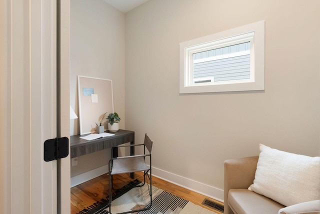 office with wood finished floors, visible vents, and baseboards