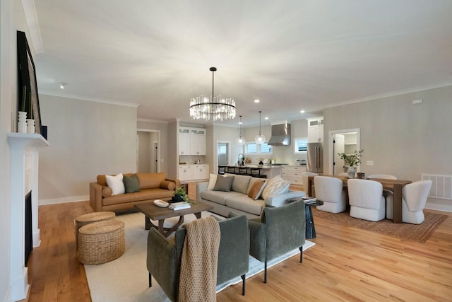 living area with a fireplace, recessed lighting, visible vents, light wood-style flooring, and ornamental molding