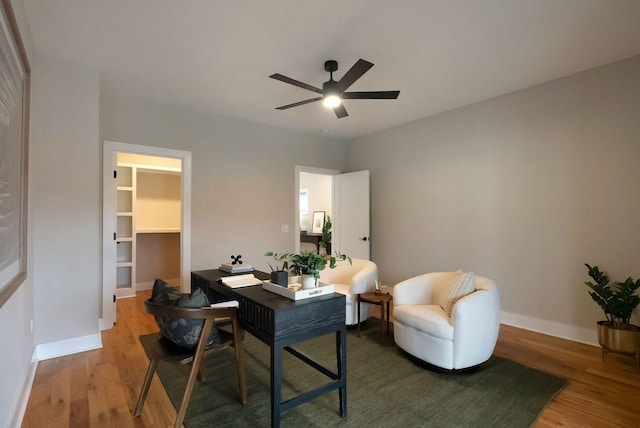 office area featuring wood finished floors, a ceiling fan, and baseboards