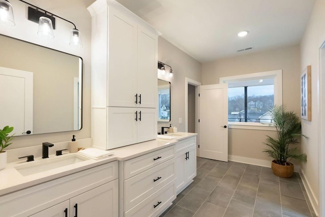 full bathroom with tile patterned flooring, a sink, visible vents, baseboards, and double vanity