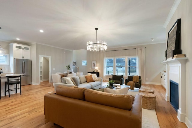 living area featuring ornamental molding, light wood-type flooring, a fireplace, and baseboards