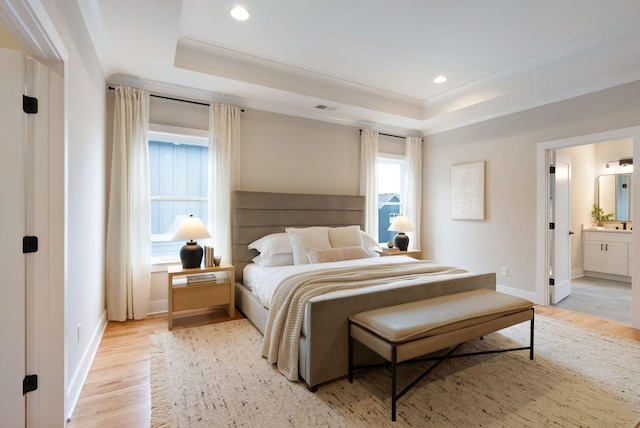 bedroom with light wood-style floors, visible vents, a raised ceiling, and recessed lighting