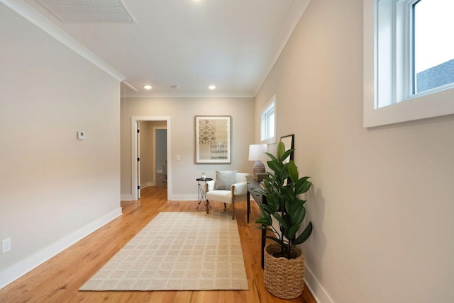 corridor featuring recessed lighting, visible vents, ornamental molding, light wood-type flooring, and baseboards