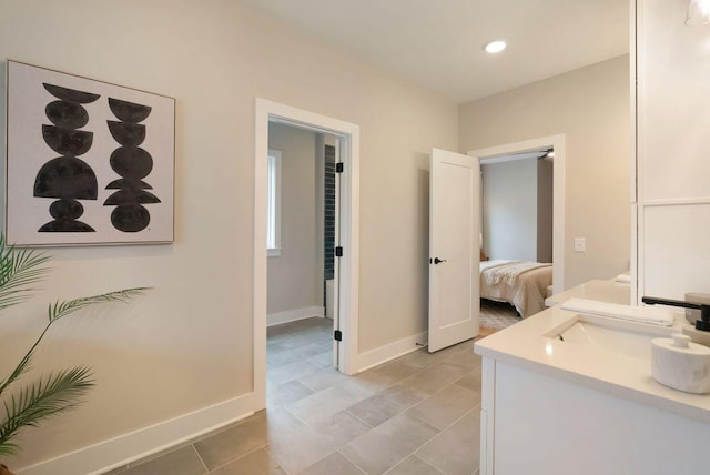 bathroom featuring recessed lighting, baseboards, connected bathroom, and vanity