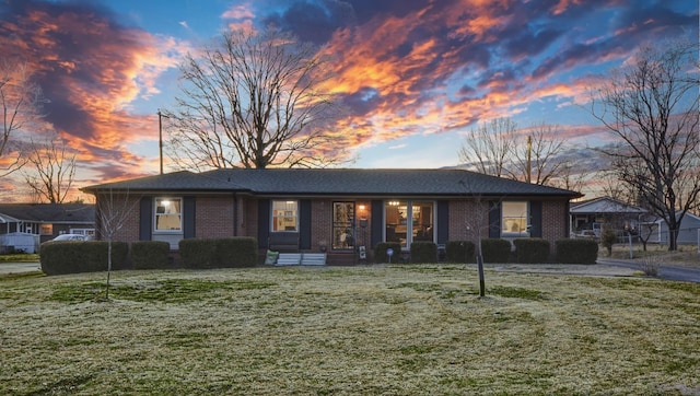 ranch-style house with a front yard and brick siding