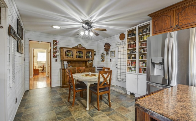 dining room featuring wooden walls and stone finish floor