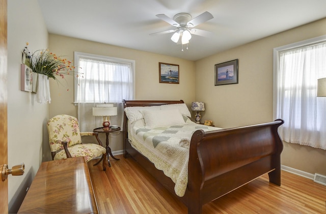 bedroom featuring ceiling fan, baseboards, and wood finished floors