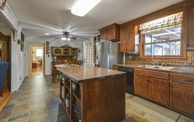 kitchen featuring black dishwasher, decorative backsplash, a kitchen island, a sink, and stainless steel fridge with ice dispenser