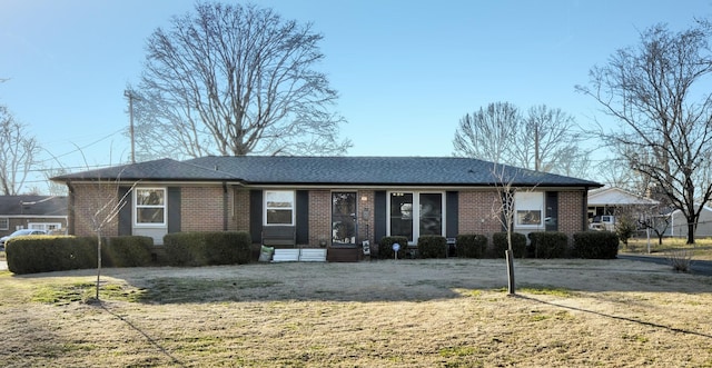 single story home with brick siding and a front yard