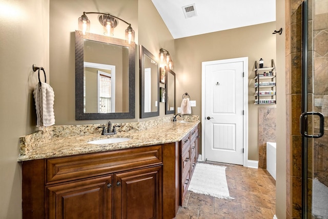 full bathroom with double vanity, a stall shower, a garden tub, stone finish flooring, and a sink