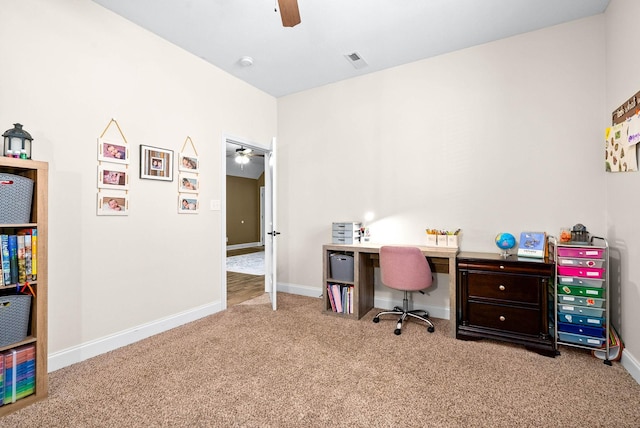 carpeted office space with baseboards, visible vents, and a ceiling fan