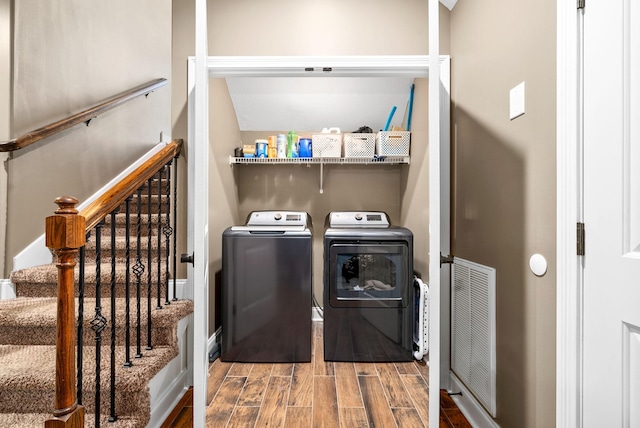 washroom featuring laundry area, wood tiled floor, visible vents, and washer and dryer