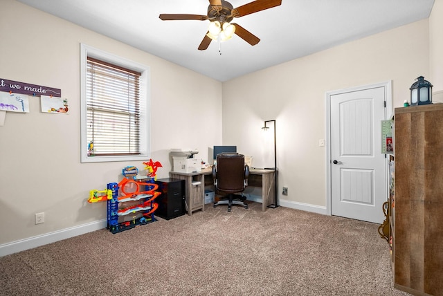 carpeted office space with baseboards and a ceiling fan