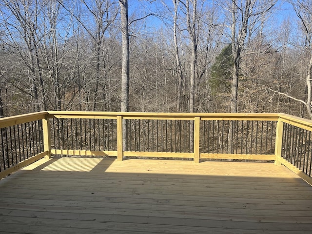 wooden terrace featuring a wooded view