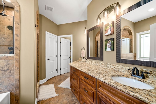 full bathroom with double vanity, visible vents, a stall shower, a sink, and baseboards