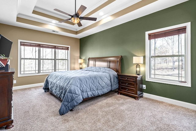 bedroom featuring carpet, multiple windows, and a tray ceiling