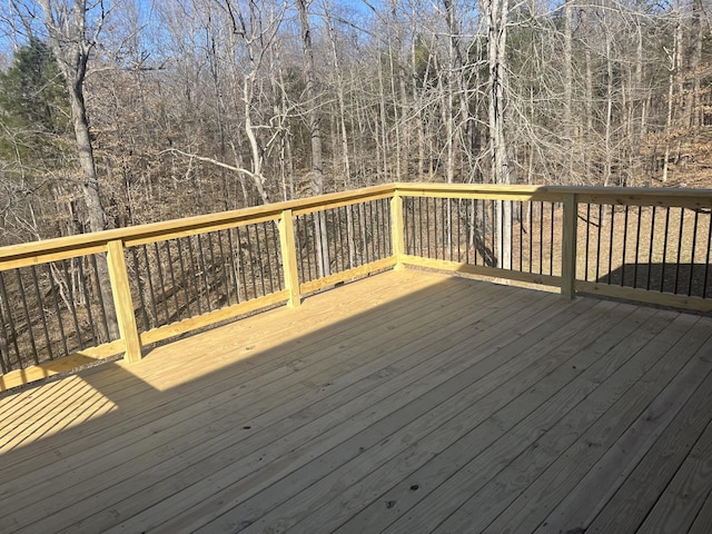 wooden terrace featuring a wooded view