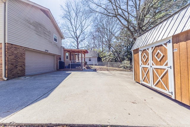 view of side of home featuring a shed, fence, an outdoor structure, and brick siding