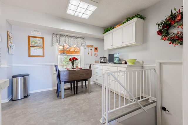 interior space featuring light countertops, white cabinetry, and baseboards