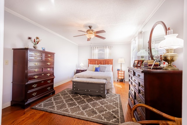 bedroom featuring ornamental molding, a textured ceiling, and wood finished floors