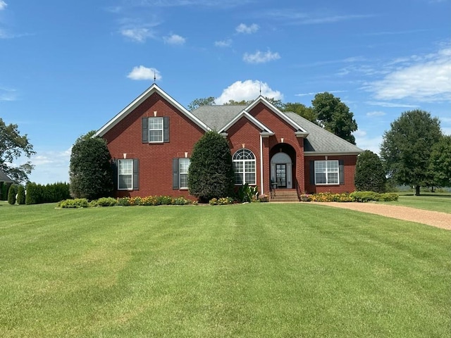 view of front of house with brick siding and a front lawn