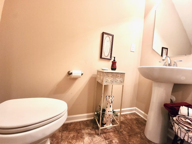 half bath featuring toilet and baseboards